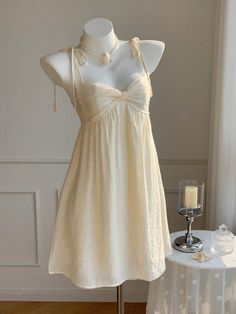 White dress with a bow detail on a mannequin with a pearl necklace