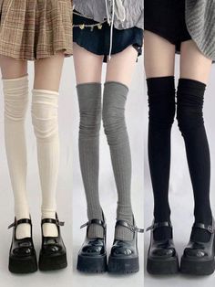 Three sets of legs wearing thigh-high socks, mini skirts, and platform shoes