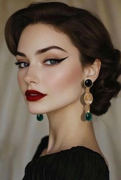 Woman with dark hair and red lipstick wearing long emerald green earrings