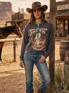 Woman in a cowboy hat and bolo tie in a western-themed outdoor setting with a horse