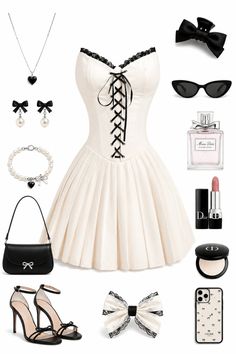 A flat lay of a white dress with black lace and various accessories