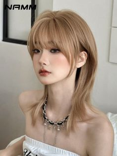 Person with blonde shag haircut and choker necklace wearing a strapless top