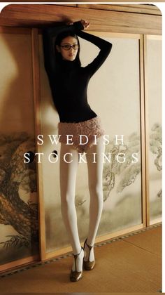 Woman in a black turtleneck and white tights posing indoors