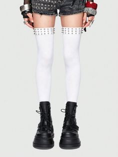 Person wearing white thigh-high socks with studded garters and black combat boots