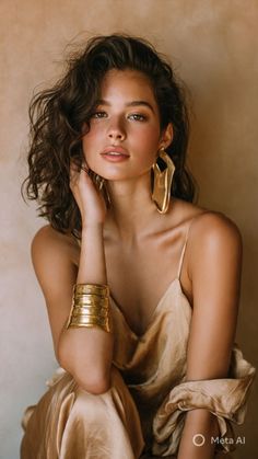 Woman with wavy hair and gold jewelry in a spaghetti strap top