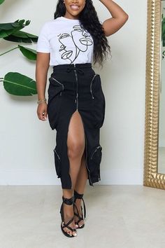 Woman in a white t-shirt and black high-slit skirt with strappy sandals