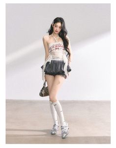 Woman with long dark hair wearing a halter top and ruffle shorts indoors