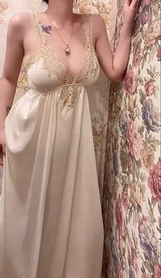 Woman in a cream nightgown with lace trim against a floral background