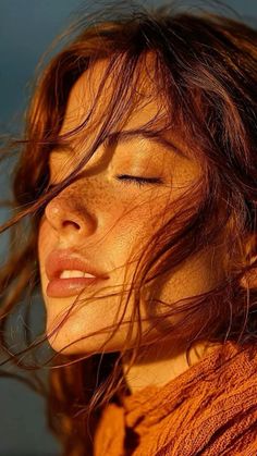 Close up of a woman with red hair and freckles in golden hour light