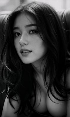 Woman with long dark hair and visible cleavage in a black and white portrait