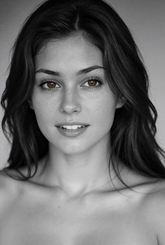 Woman with long dark hair and brown eyes in a black and white portrait
