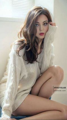 Woman in a white sweater with exposed skin posing indoors
