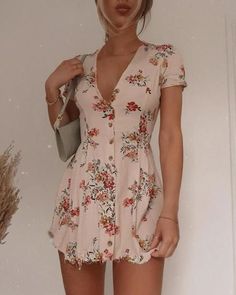 Woman in a floral short dress with a shoulder bag indoors