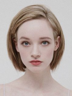 Woman with short blonde hair and blue eyes in a portrait shot