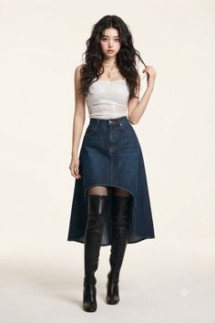 Woman with long wavy hair wearing a denim skirt and thigh-high boots in a studio