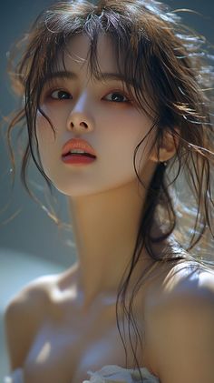 Woman with wet, messy hair and exposed shoulders in soft lighting