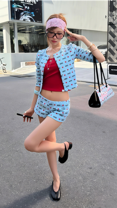 Woman in a red cropped top and blue shorts posing outdoors