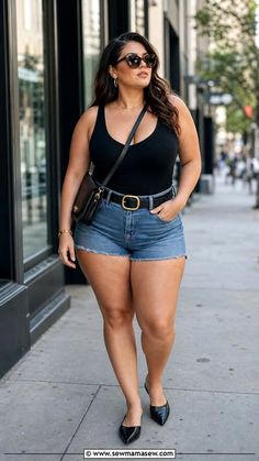 Woman in denim shorts and a black tank top walking on a city street