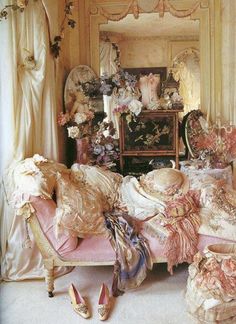 Shabby chic bedroom with a pink chaise lounge, lace pillows, and vintage decor