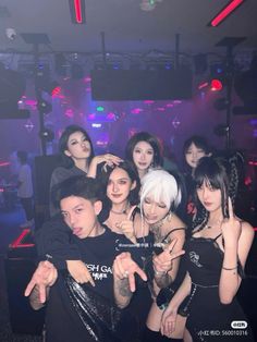 Group of people posing in a nightclub with neon lighting