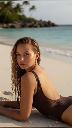 Woman in a brown swimsuit lying on a sandy beach with wet hair