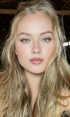 Close-up portrait of a woman with long blonde hair and green eyes