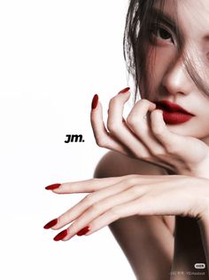 Close up of a woman with red lipstick and nails, hair partially covering her face