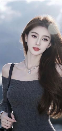 Woman with long brown hair wearing an off-shoulder top and necklace outdoors