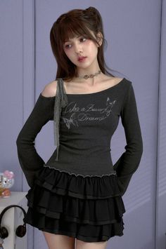 Woman with long hair wearing an off-shoulder top and ruffle skirt indoors