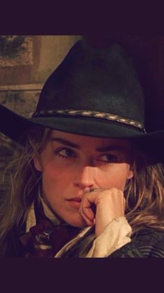 Woman in a cowboy hat with dramatic lighting on her face