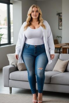 Blonde woman in ripped jeans and a white shirt standing indoors