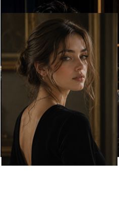 Woman in a black dress with an exposed back and updo hair looking over her shoulder