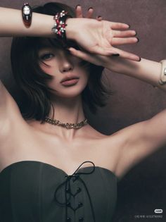 Woman with short hair and a strapless top covering her face with her hands