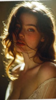 Woman with long hair and exposed shoulders, backlit by warm light