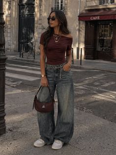 Woman in an off-shoulder top and baggy jeans on a city street