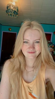 Young woman with long blonde hair and blue eyes smiling at the camera