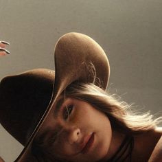 Woman in a cowboy hat with blonde hair and warm lighting