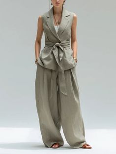 Woman in a sleeveless vest and wide leg pants with a belted waist