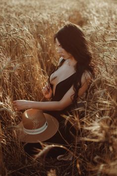 Woman with long dark hair in a deep V-neck dress in a wheat field