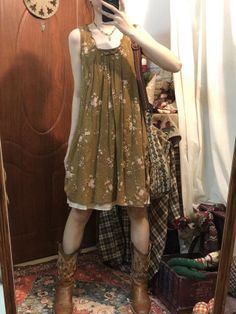 Person in a floral dress and cowboy boots taking a mirror selfie