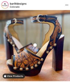 Pair of high-heeled leather shoes with floral tooling and studded details