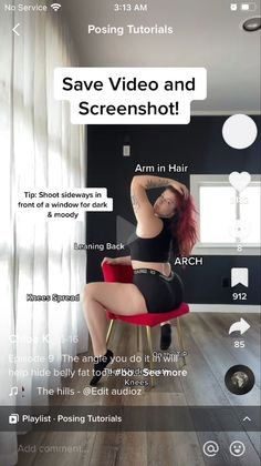 Woman with red hair in a black sports bra and shorts posing on a red chair