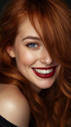 Close-up portrait of a smiling woman with red hair and blue eyes