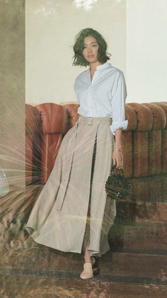 Woman in a white shirt and long skirt with a handbag, double exposure effect
