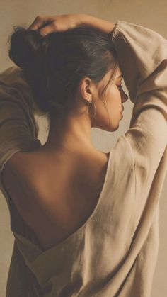 Woman with dark hair in an updo, wearing a top with an exposed back