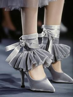 Close up of gray velvet high heels with ruffled trim and ribbon ties