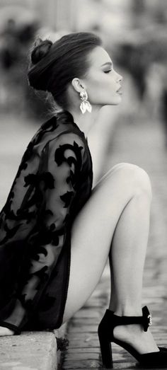 Woman in a sheer top and high heels with an updo, in black and white