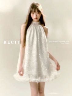 Woman in a white sequined dress with a ruffled hem and long hair