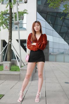 Woman in a velvet top and mini skirt posing outdoors