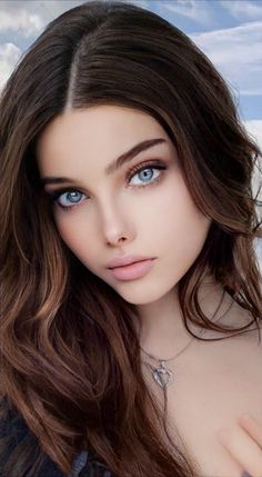 Woman with long brown hair and blue eyes wearing a heart necklace